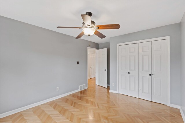 unfurnished bedroom featuring a ceiling fan, a closet, visible vents, and baseboards