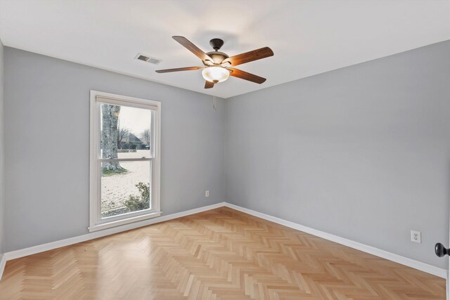 empty room with baseboards, visible vents, and a ceiling fan