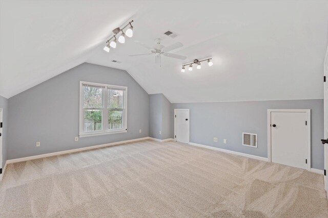 bonus room featuring light colored carpet, visible vents, vaulted ceiling, and baseboards