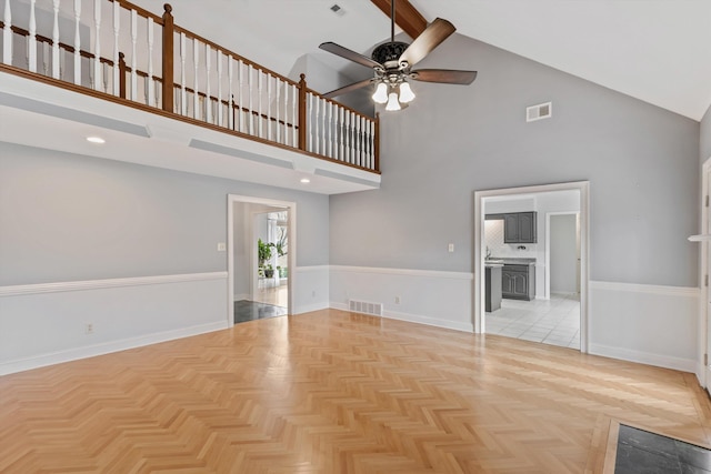 unfurnished living room featuring high vaulted ceiling, visible vents, and baseboards