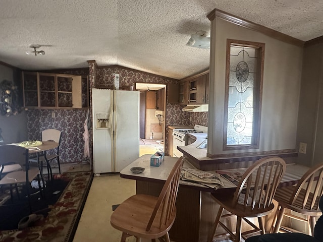 kitchen with light carpet, a peninsula, white appliances, vaulted ceiling, and light countertops