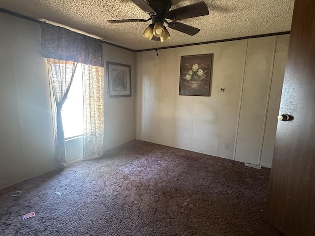 unfurnished room with carpet floors, ceiling fan, and a textured ceiling