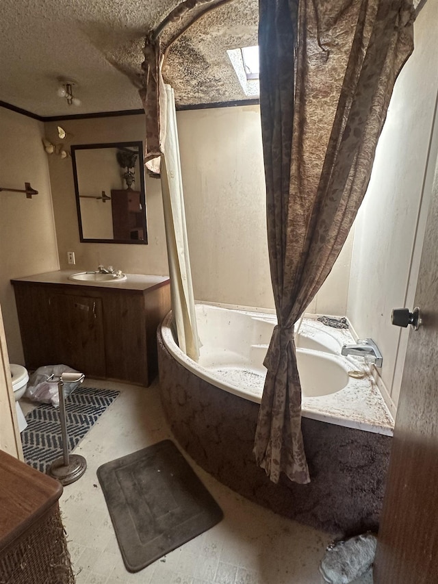 full bathroom featuring a skylight, vanity, and a textured ceiling