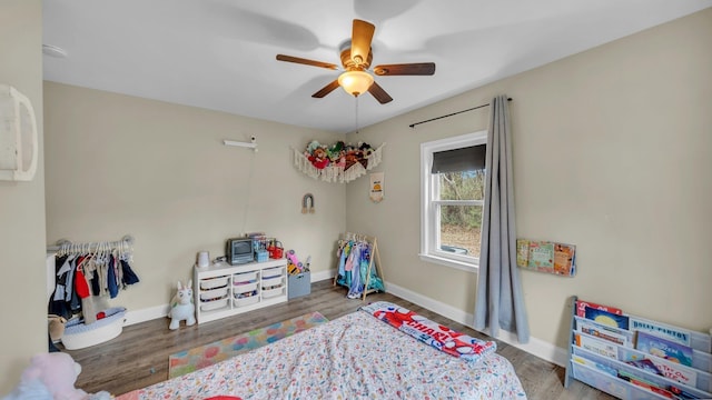 bedroom featuring ceiling fan, baseboards, and wood finished floors