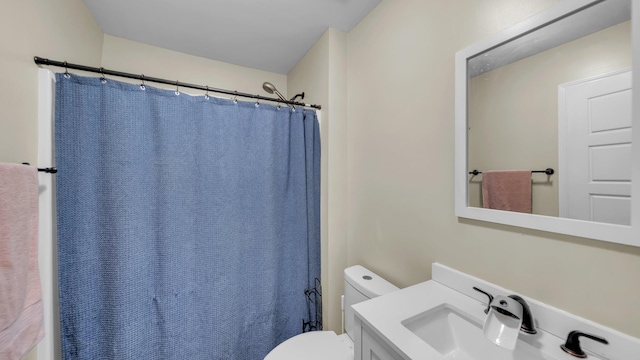 bathroom with toilet, a shower with curtain, and vanity