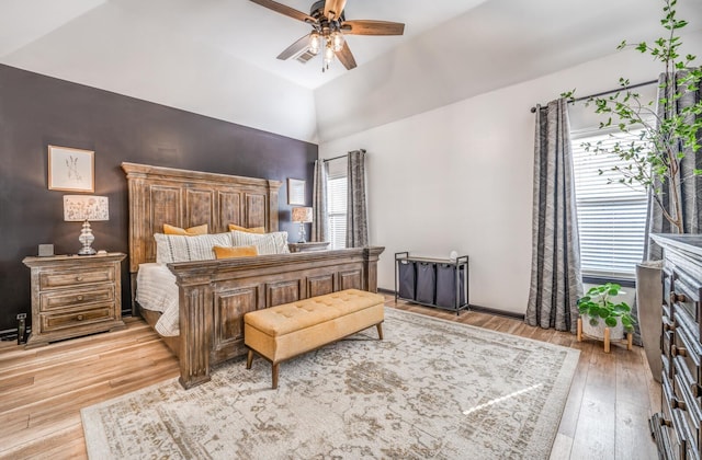 bedroom featuring a ceiling fan, vaulted ceiling, baseboards, and wood finished floors