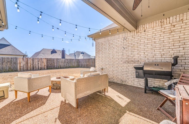 view of patio with a ceiling fan, an outdoor living space with a fire pit, a fenced backyard, and grilling area