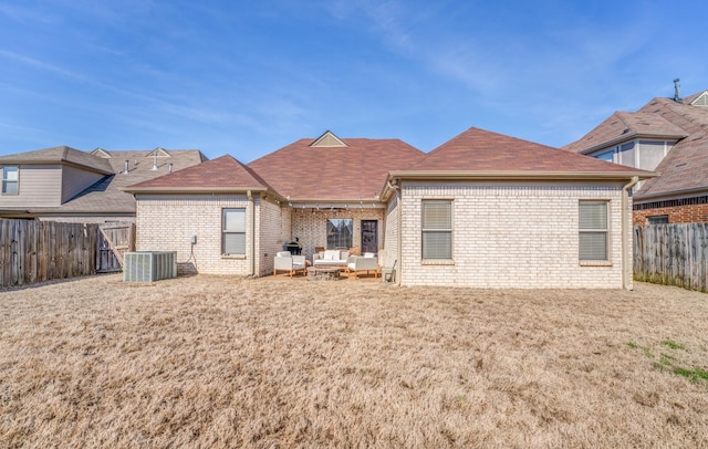 rear view of property with a yard, a fenced backyard, brick siding, and an outdoor hangout area