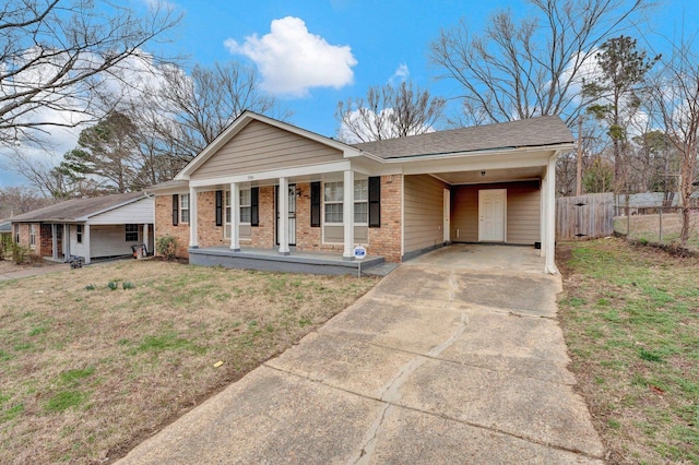 view of front of house with driveway, a porch, a carport, and brick siding