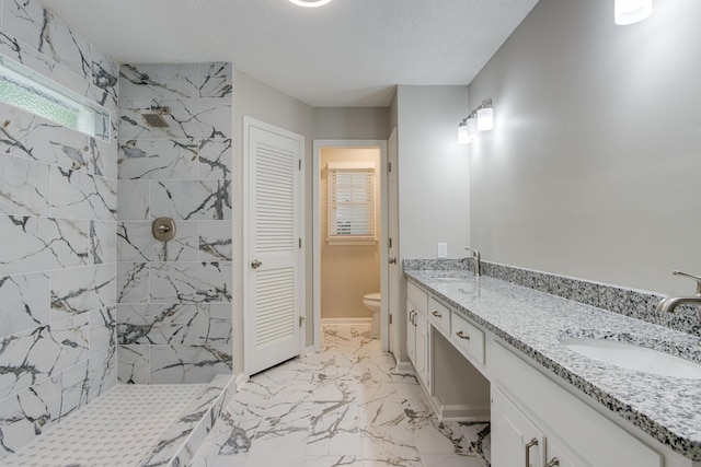 bathroom with marble finish floor, a sink, toilet, and walk in shower