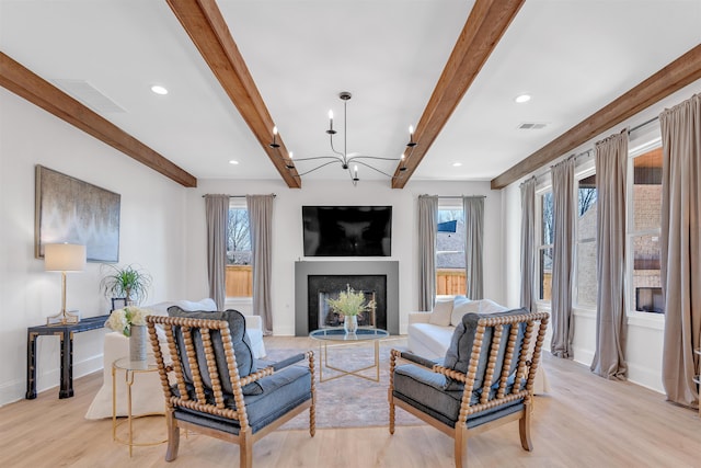 living room featuring visible vents, light wood-style flooring, beamed ceiling, a fireplace, and recessed lighting