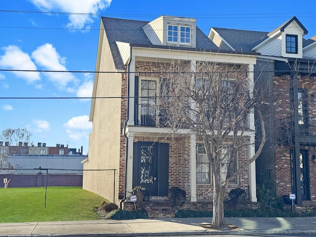 view of front of house with fence, a front lawn, and brick siding