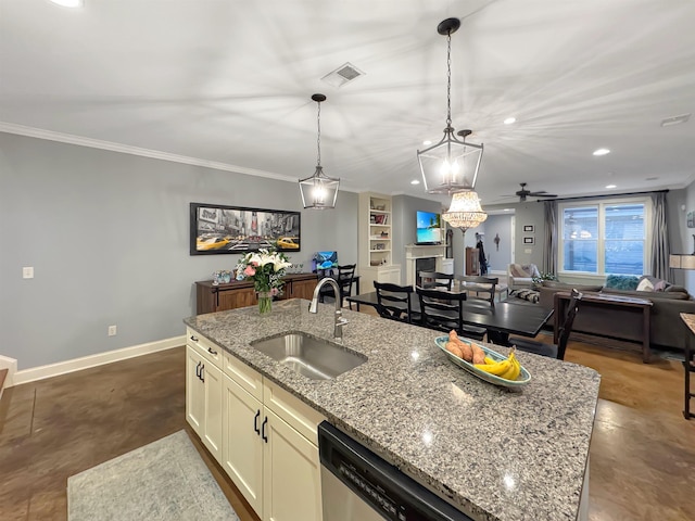 kitchen featuring light stone counters, visible vents, hanging light fixtures, open floor plan, and a sink