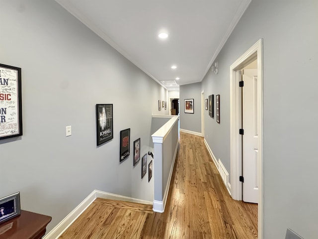 corridor featuring recessed lighting, visible vents, baseboards, light wood-style floors, and ornamental molding