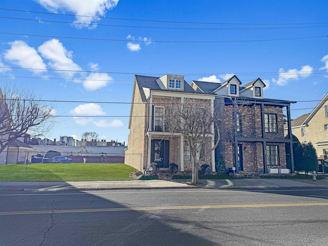 view of front of property featuring fence and a front lawn