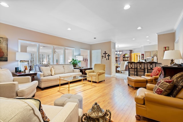 living area featuring crown molding, recessed lighting, a chandelier, and light wood-style floors