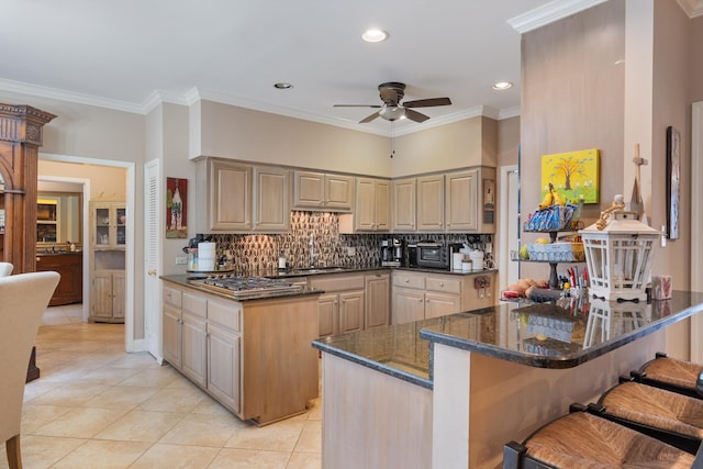 kitchen featuring light tile patterned floors, tasteful backsplash, dark stone countertops, crown molding, and stainless steel gas cooktop