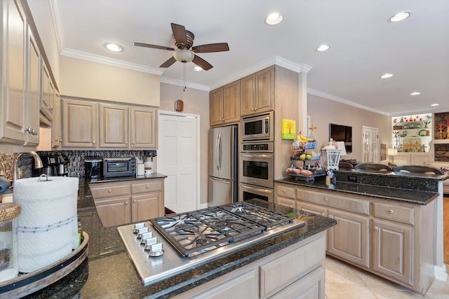 kitchen featuring light brown cabinets, appliances with stainless steel finishes, dark stone countertops, and ornamental molding