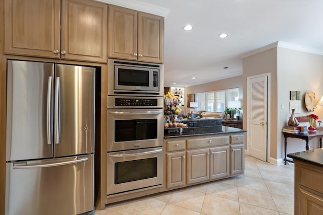 kitchen with light tile patterned floors, recessed lighting, appliances with stainless steel finishes, ornamental molding, and dark stone countertops