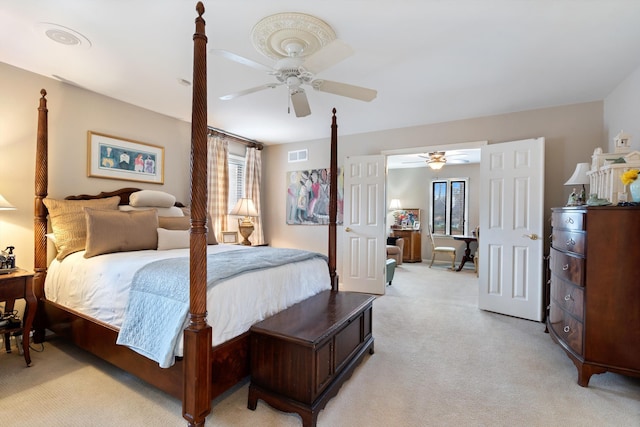 bedroom with ceiling fan, multiple windows, visible vents, and light colored carpet