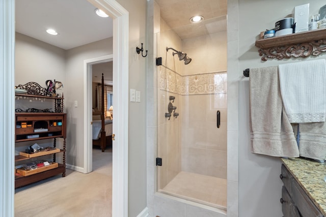 full bath featuring connected bathroom, recessed lighting, vanity, baseboards, and a shower stall