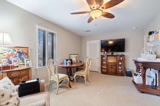 dining room with light carpet, ceiling fan, and visible vents