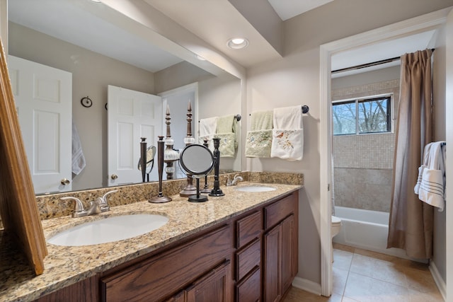 bathroom with tile patterned flooring, a sink, toilet, and double vanity