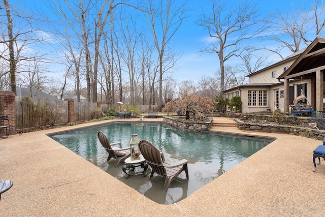 view of swimming pool featuring a patio area, fence, and a fenced in pool