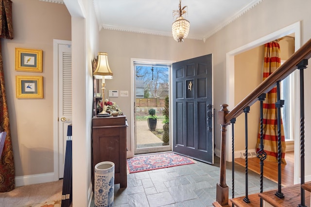 entrance foyer featuring ornamental molding, stone finish flooring, baseboards, and stairs