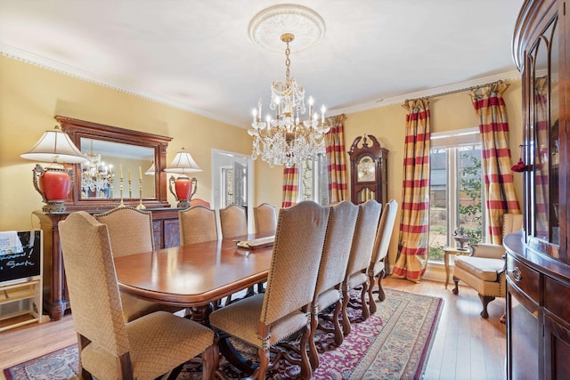 dining area with ornamental molding, light wood-style floors, and a notable chandelier