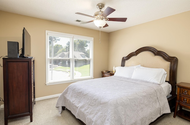 bedroom with light carpet, ceiling fan, visible vents, and baseboards