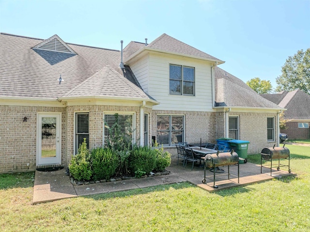 back of house with a yard, brick siding, a patio area, and a shingled roof