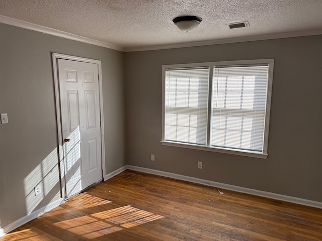 unfurnished bedroom with crown molding, visible vents, dark wood-type flooring, a textured ceiling, and baseboards