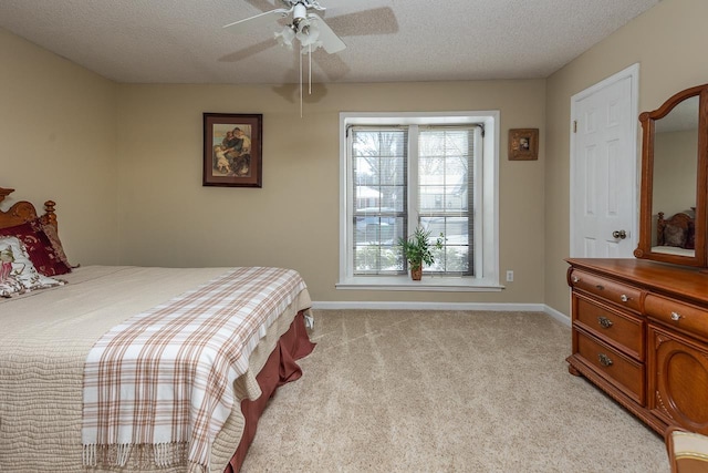 bedroom with light carpet, baseboards, a ceiling fan, and a textured ceiling