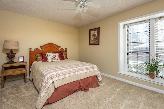 bedroom featuring light carpet, multiple windows, baseboards, and a textured ceiling