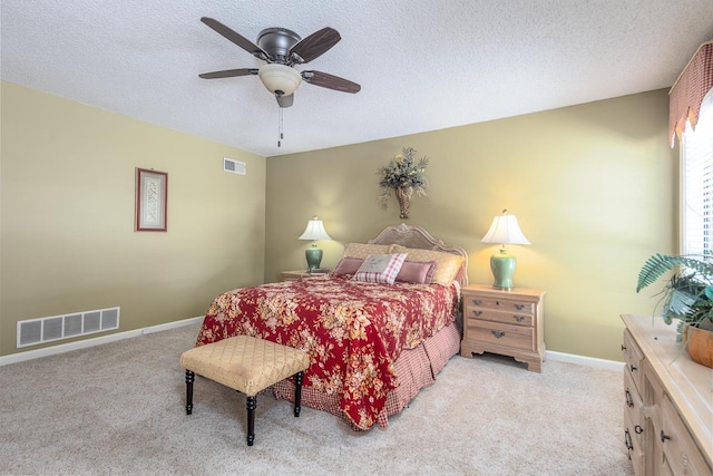 bedroom with light colored carpet, visible vents, and a textured ceiling