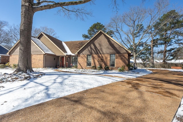 view of front of home featuring fence and brick siding