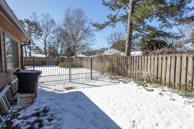 snowy yard featuring a fenced backyard