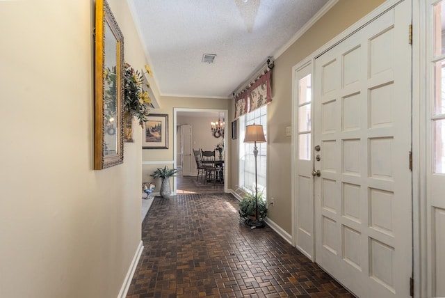 entrance foyer featuring brick floor, baseboards, visible vents, and a textured ceiling