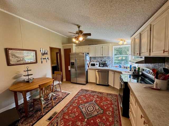 kitchen with stainless steel appliances, lofted ceiling, decorative backsplash, ornamental molding, and a textured ceiling