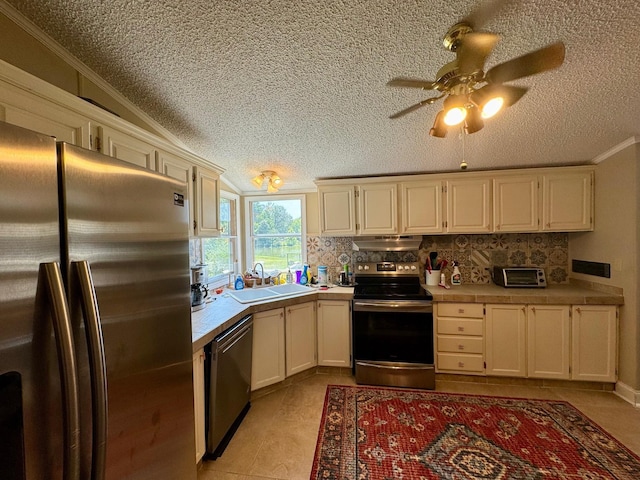 kitchen featuring decorative backsplash, stainless steel appliances, crown molding, light countertops, and a sink