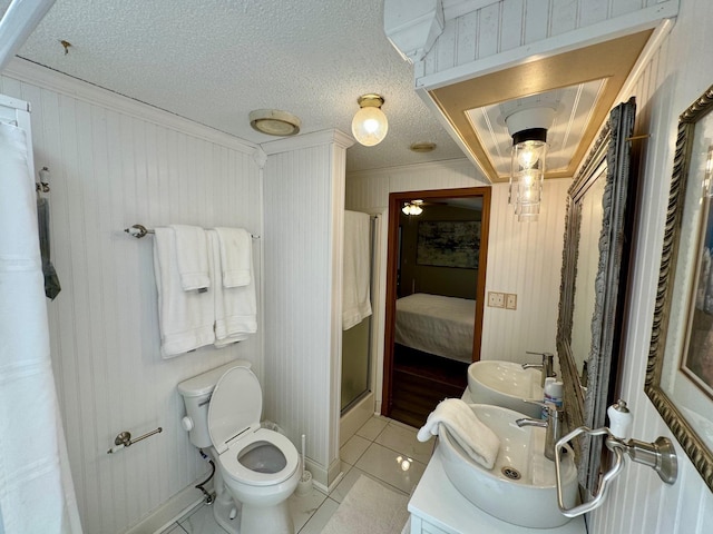 bathroom featuring a sink, tile patterned floors, double vanity, a stall shower, and ensuite bath