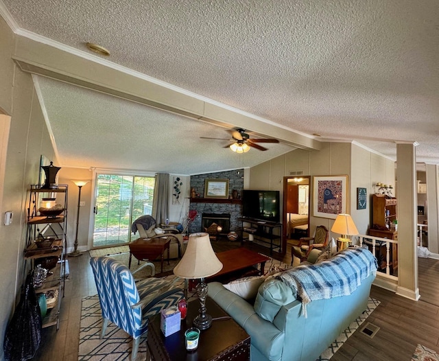 living room featuring vaulted ceiling with beams, a stone fireplace, dark wood-style flooring, and a ceiling fan