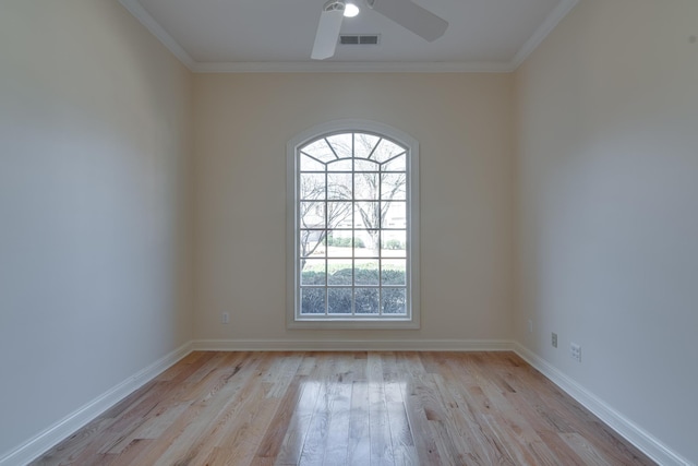 empty room with light wood-type flooring, baseboards, visible vents, and crown molding