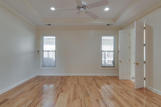 empty room with baseboards, ornamental molding, visible vents, and light wood-style floors