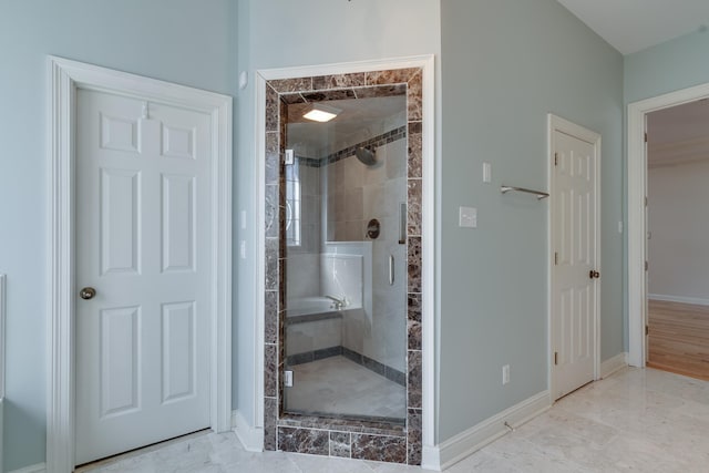 bathroom featuring a stall shower and baseboards