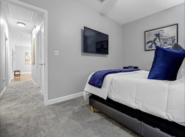 bedroom featuring attic access, light carpet, and baseboards