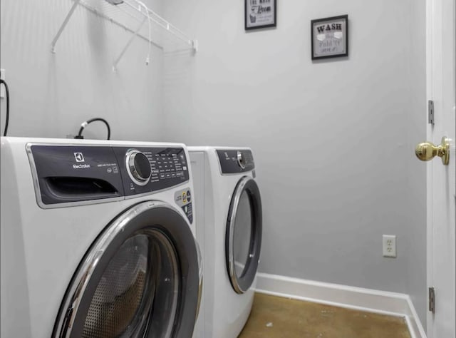 laundry area with laundry area, washer and clothes dryer, and baseboards