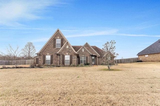 traditional home with fence, a front lawn, and brick siding