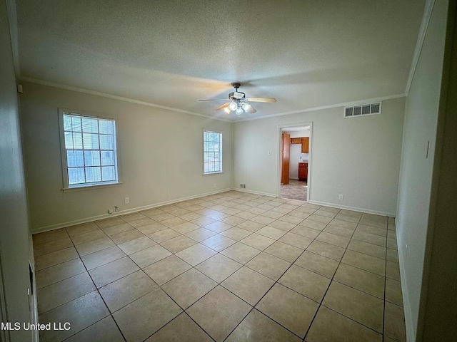 empty room with light tile patterned floors, visible vents, ornamental molding, a ceiling fan, and a textured ceiling